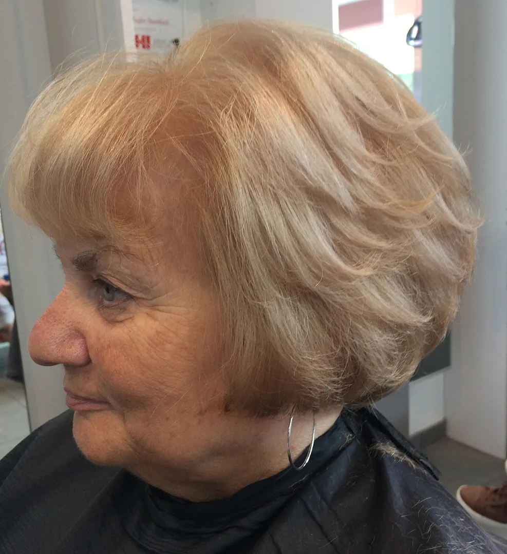 Femme de 70 ans avec carré blond fraise chaud et doux, de profil
