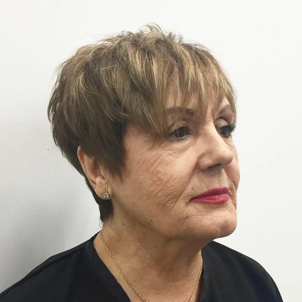 Femme de 70 ans avec carré brun chaud à frange effilée, de face