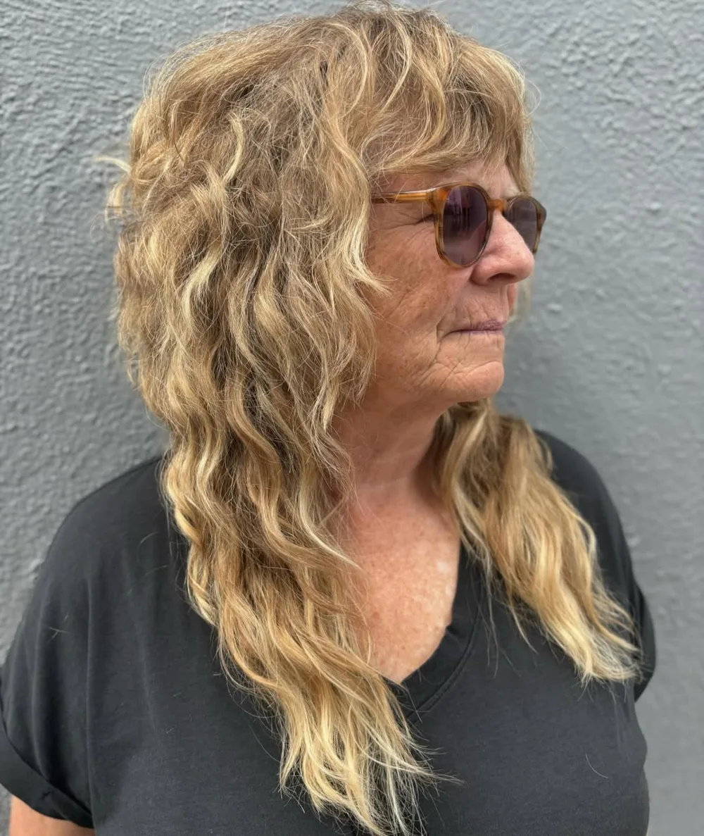 Femme de 70 ans avec cheveux longs blonds ondulés et lunettes, de profil
