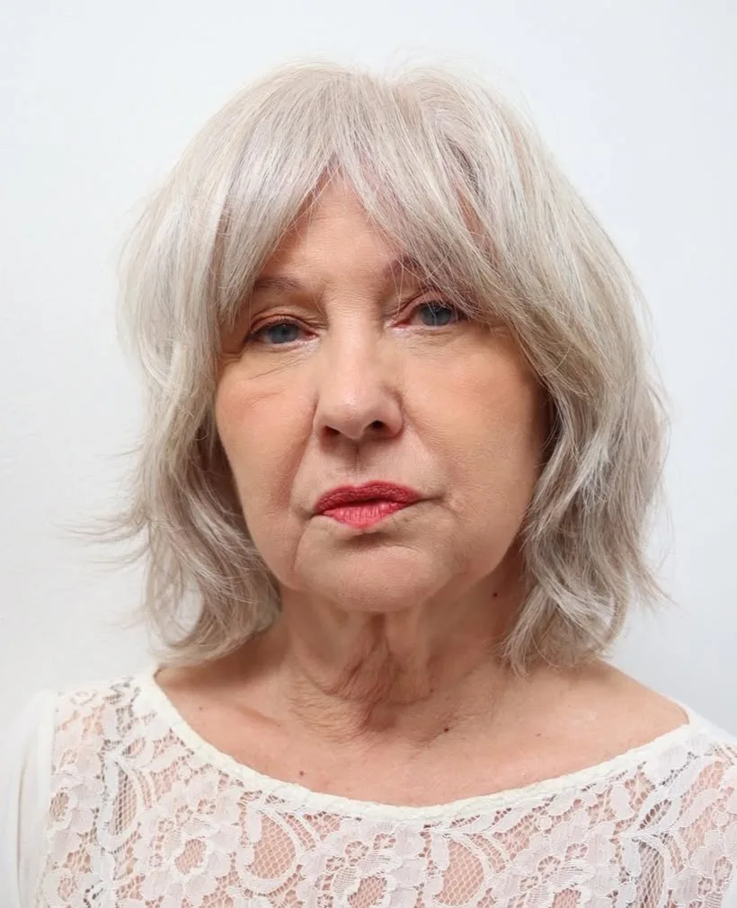 Femme de 70 ans avec coupe shag argentée pleine de couches, de face