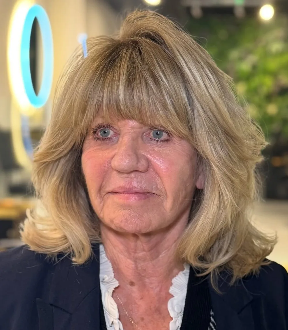 Femme de 70 ans avec long carré volumineux ondulé façon Farrah Fawcett, de face