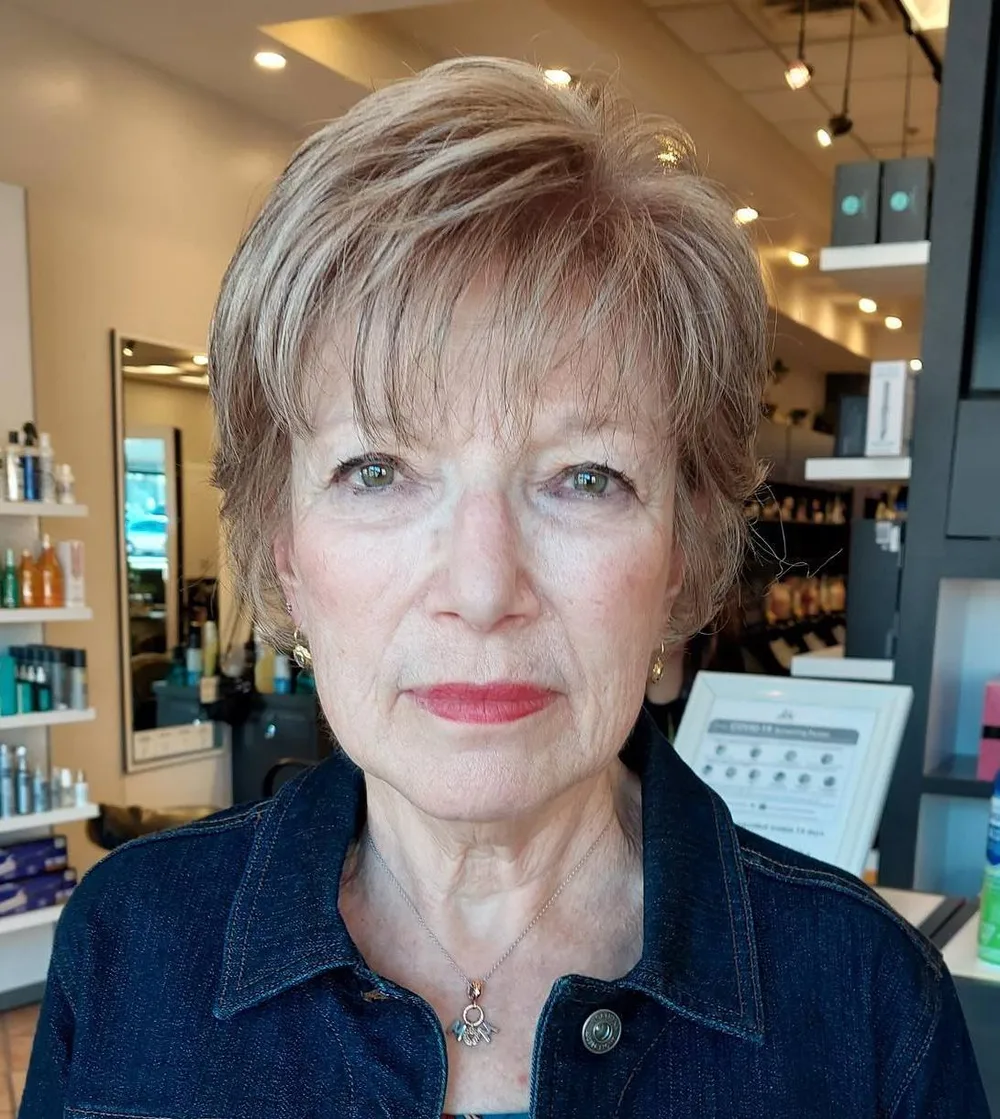 Femme de 70 ans avec pixie blond à lowlights, lunettes, de face
