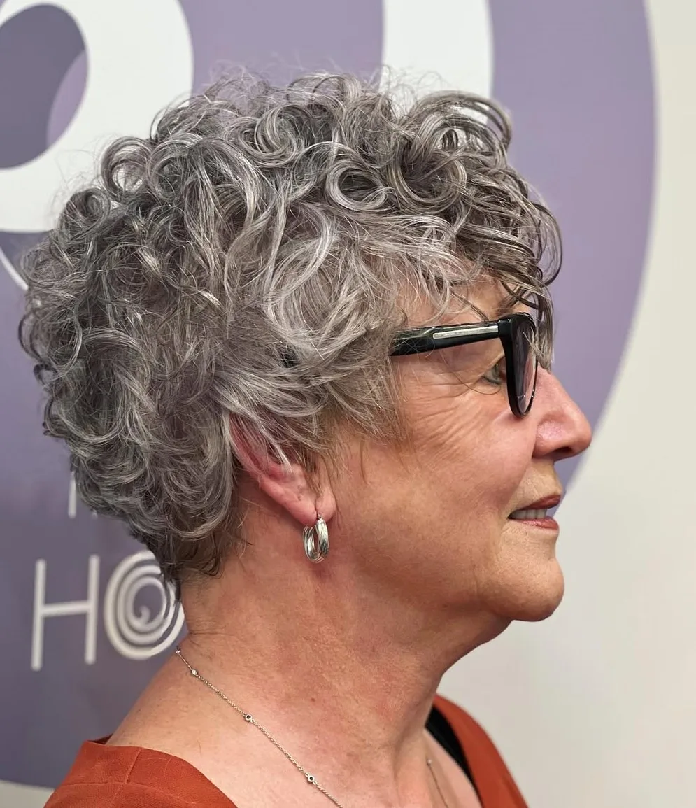 Femme de 70 ans avec pixie bouclé gris naturel et lunettes, de profil