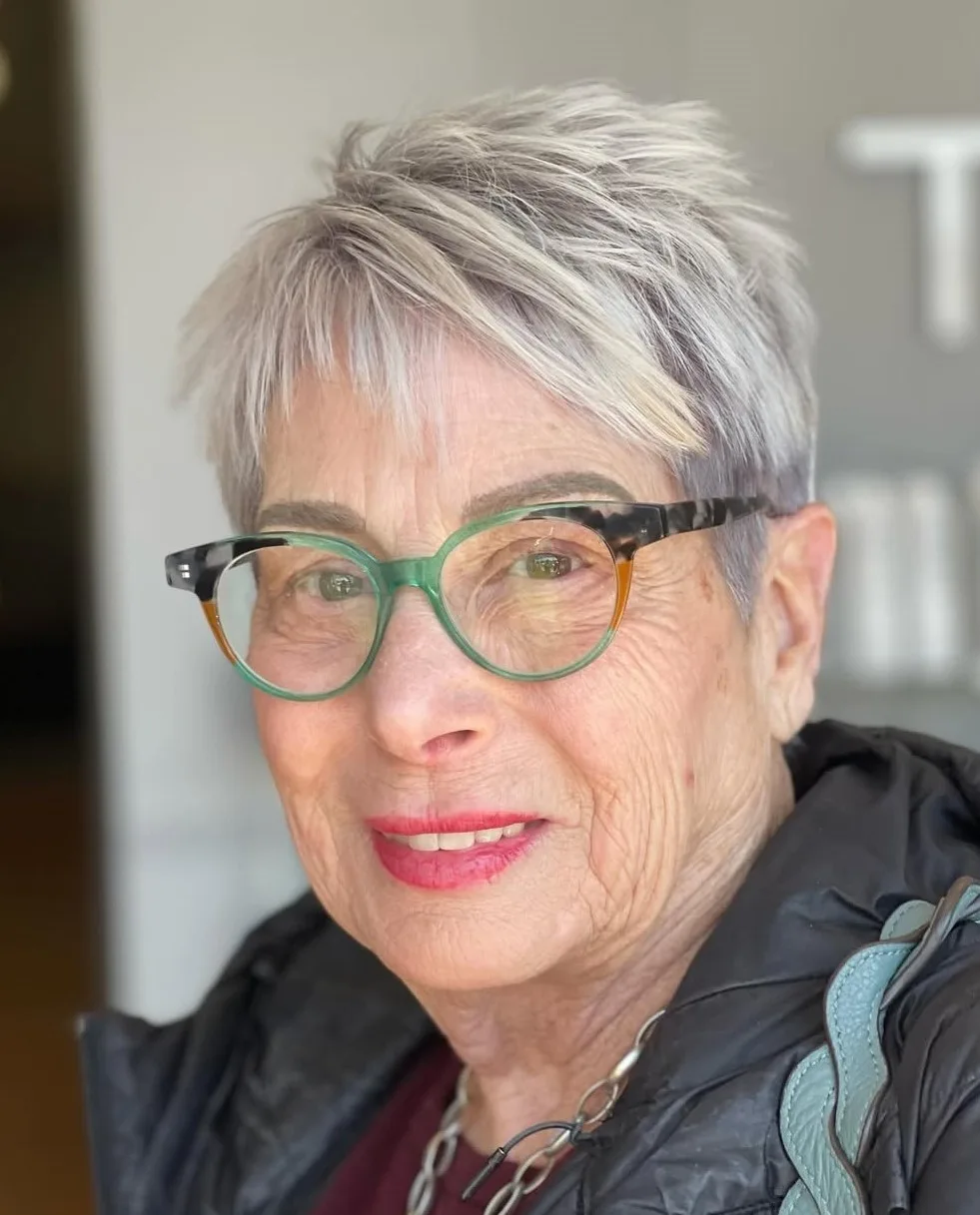 Femme de 70 ans avec pixie classique gris et lunettes colorées, de face