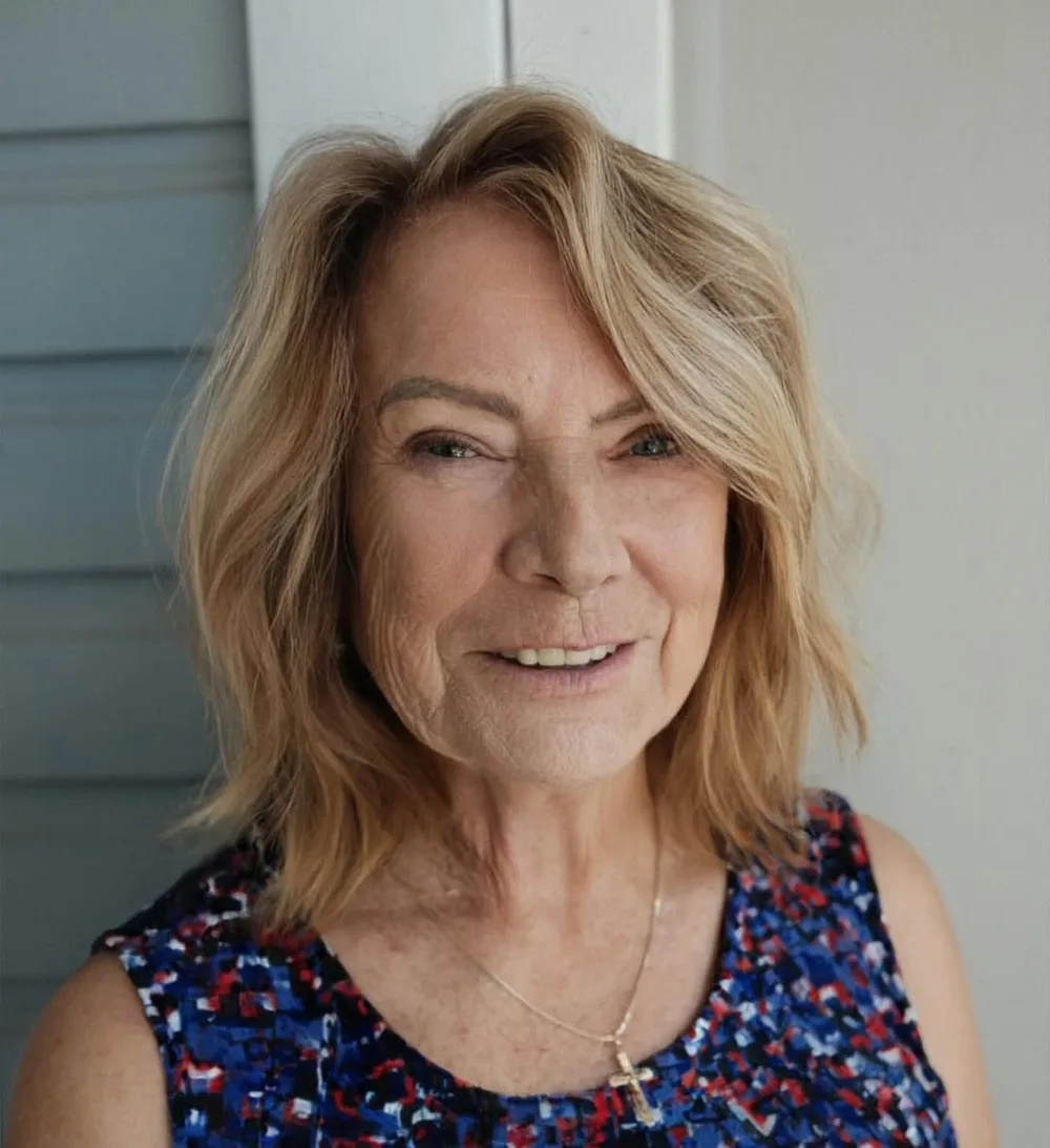 Femme de 70 ans avec shag moderne blond effilé et frange, de face