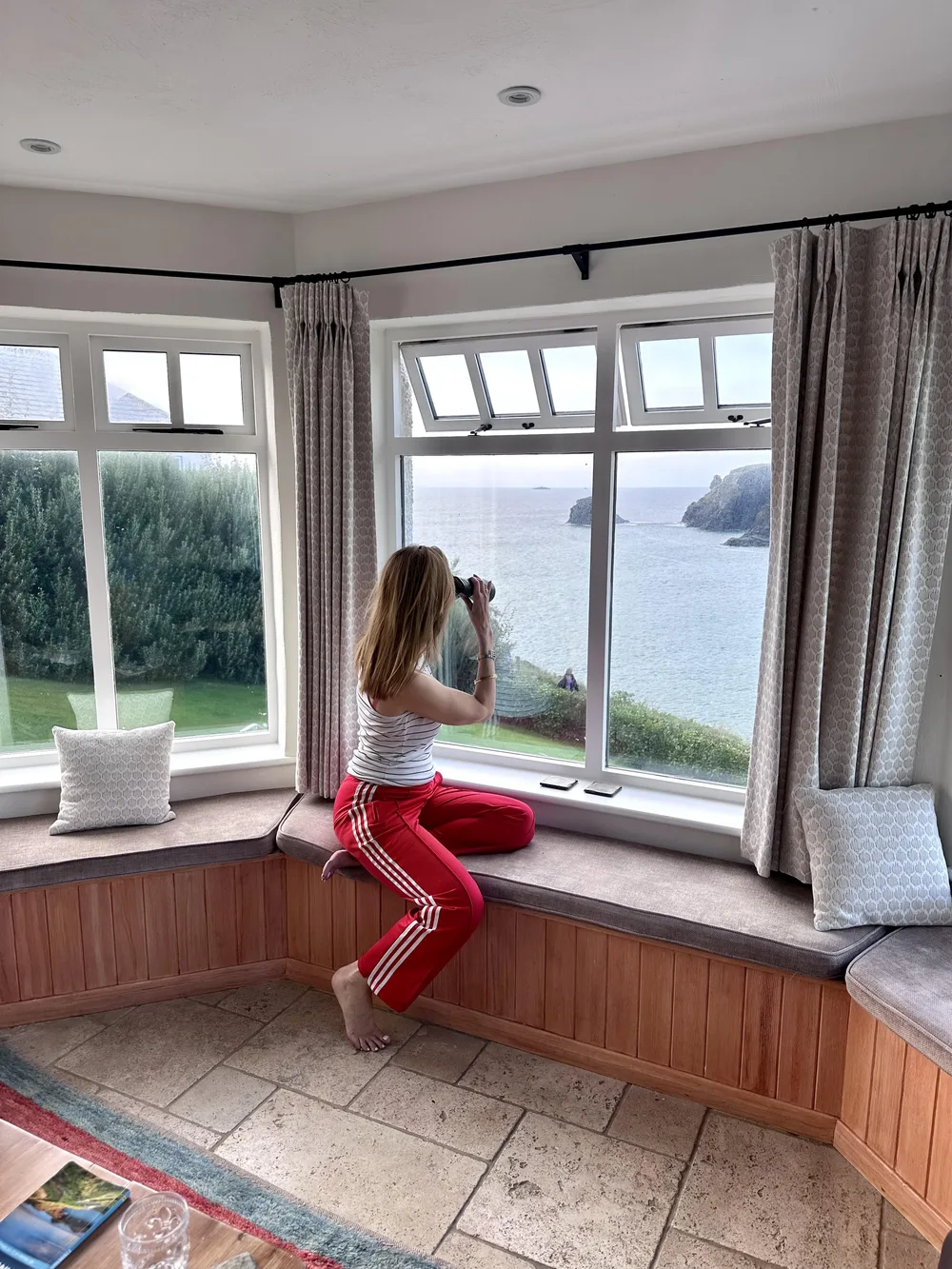 Femme mûre en pantalon sportif rouge et haut en maille pour une tenue décontractée