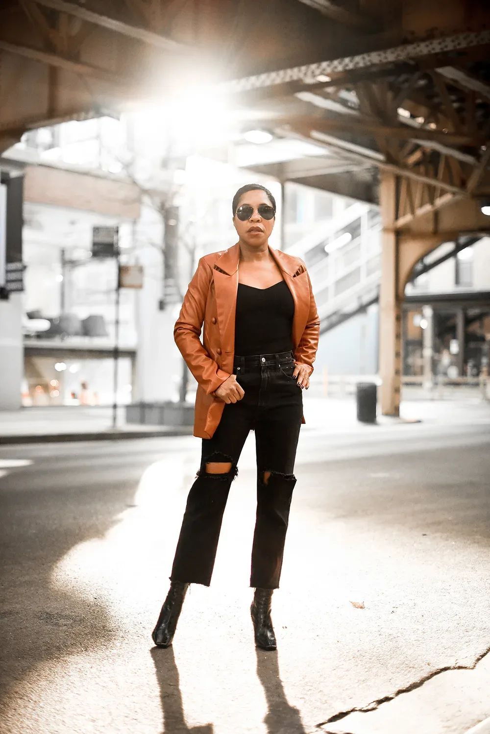 Femme mûre en veste cognac portée sur un total look noir