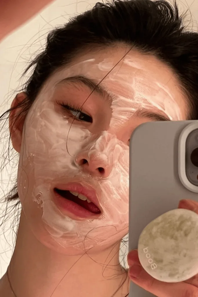 Femme posant un masque en tissu hydratant sur son visage