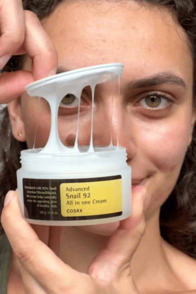 Femme tenant un pot de crème coréenne à la bave d'escargot