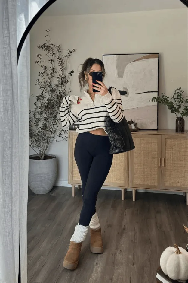 Haut court rayé noir et blanc porté avec un legging noir et des boots fourrées