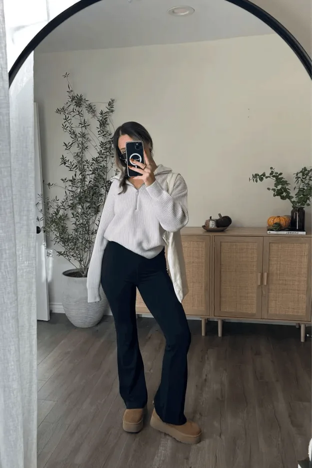 Hoodie blanc porté avec un pantalon flare noir et des boots fourrées