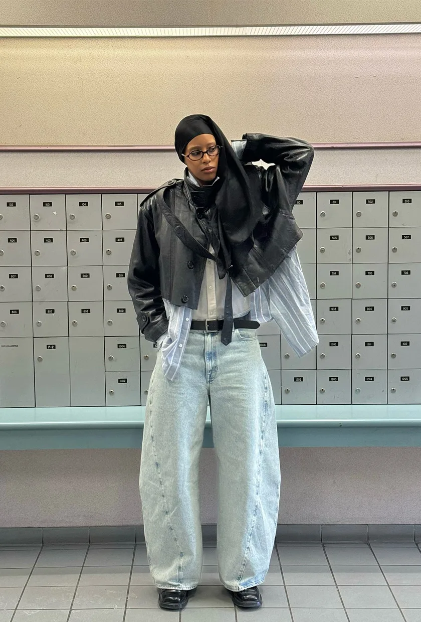 Jean barrel clair avec veste en cuir marron et chemises superposées