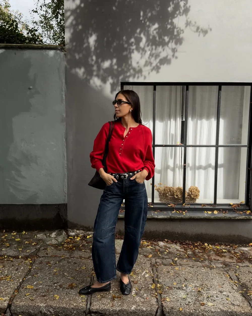 Jean brut coupe horseshoe avec pull rouge, ceinture noire et ballerines