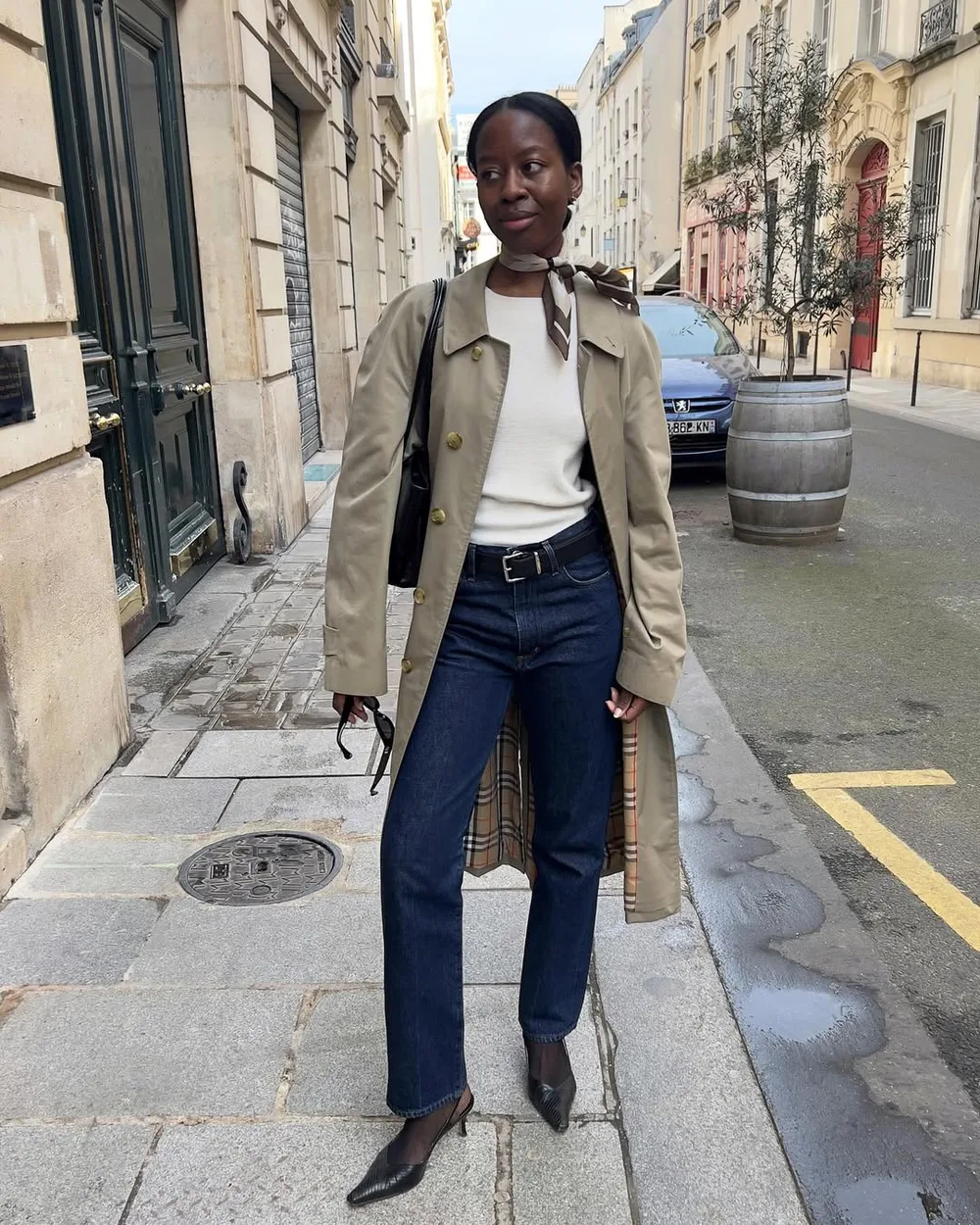 Jean brut droit avec trench beige, pull crème, foulard en soie et escarpins noirs