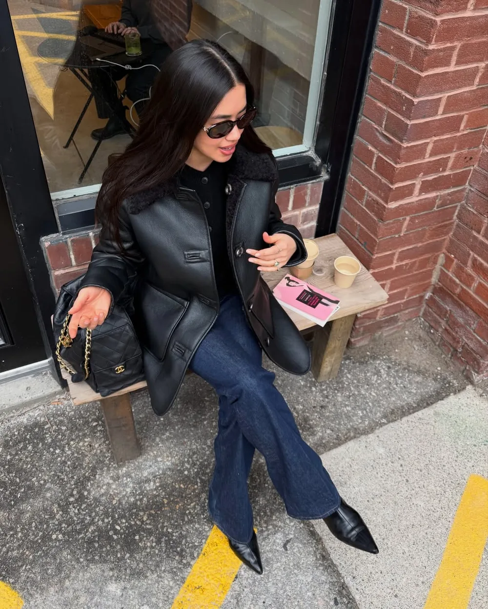Jean brut droit avec veste en cuir noire, pull noir et escarpins pointus