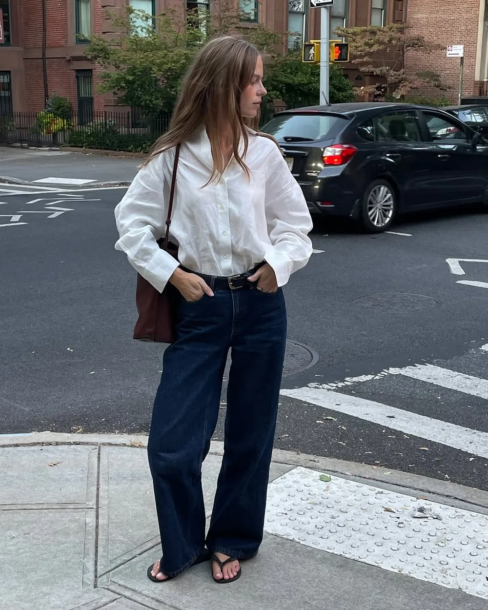 Jean brut large avec chemise blanche oversize et sandales noires