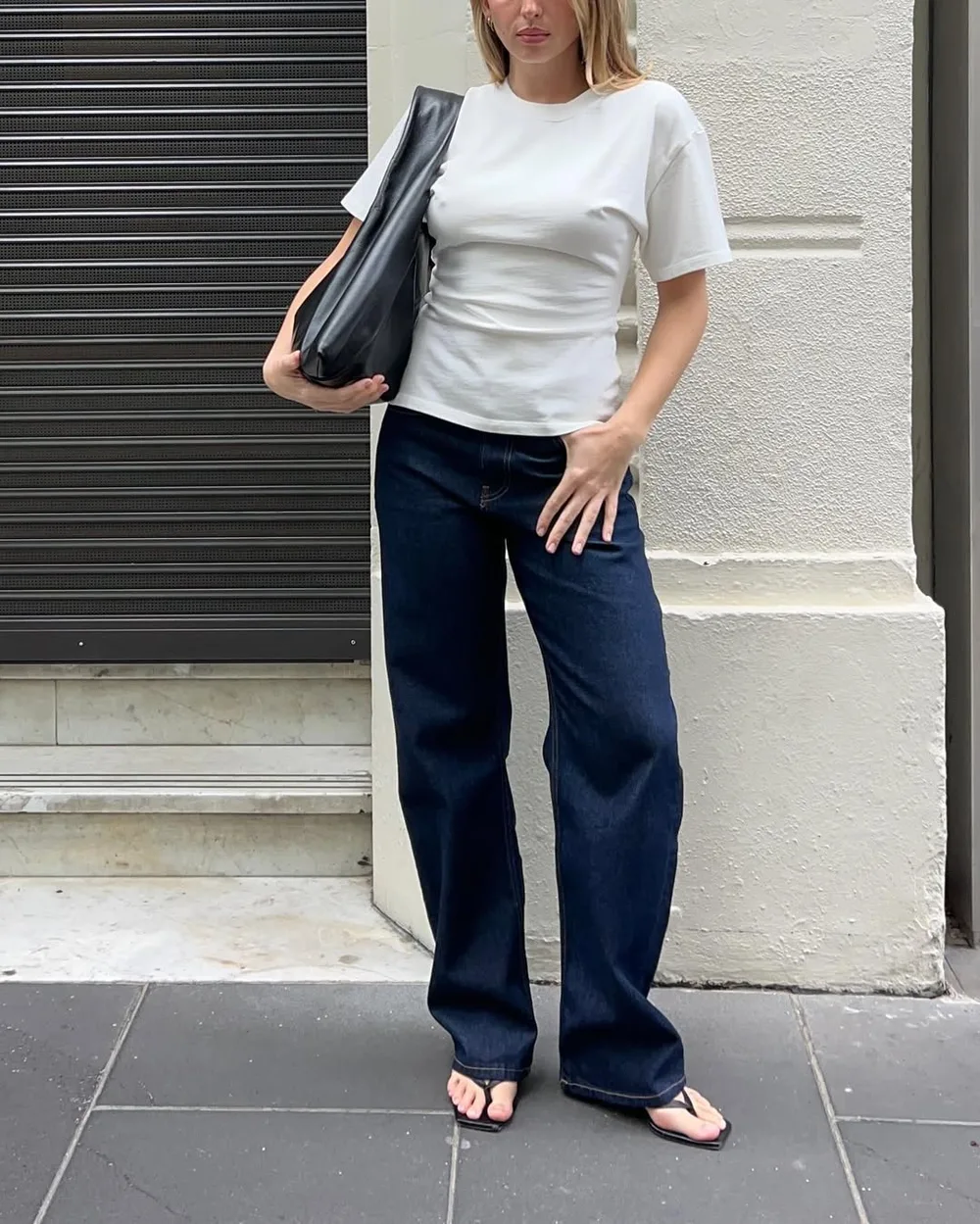 Jean brut large avec tee-shirt blanc ajusté, sandales noires et sac en cuir