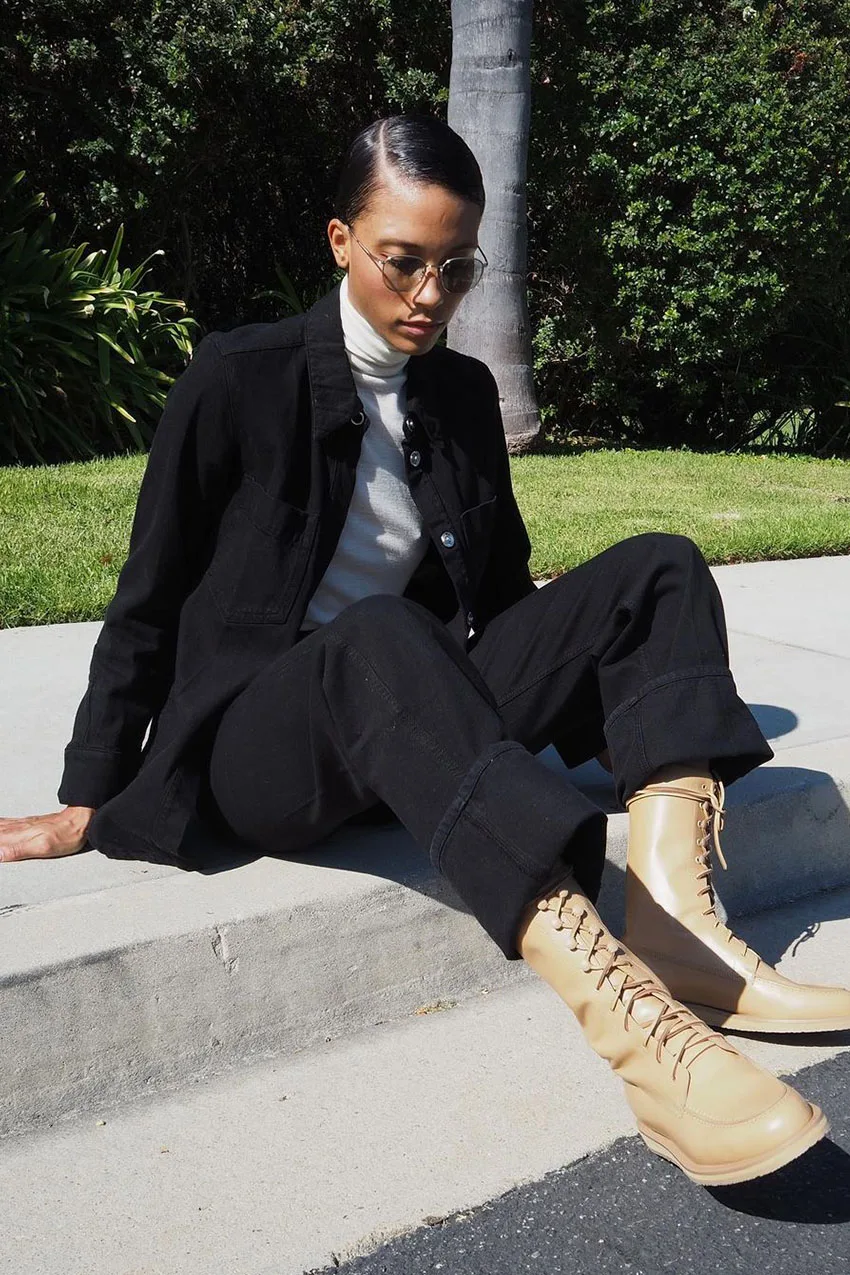 Jean noir ample avec blazer noir, chemise blanche et bottines à lacets beige