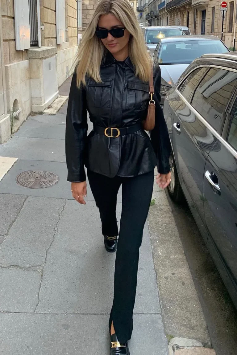 Jean noir bootcut avec veste en cuir noire ceinturée et sac porté épaule