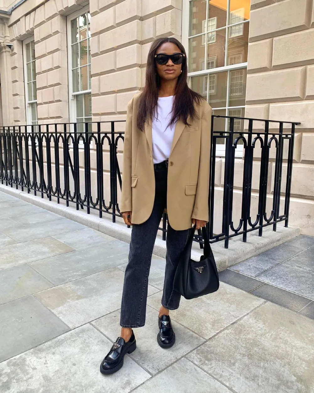 Jean noir court avec blazer camel, tee-shirt blanc et mocassins épais