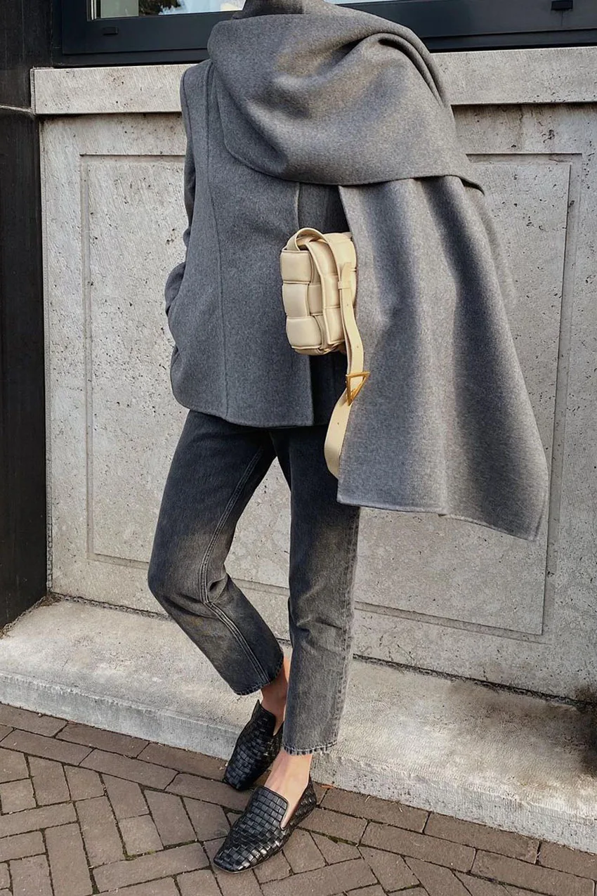 Jean noir délavé avec pull gris oversize, écharpe assortie et chaussures noires
