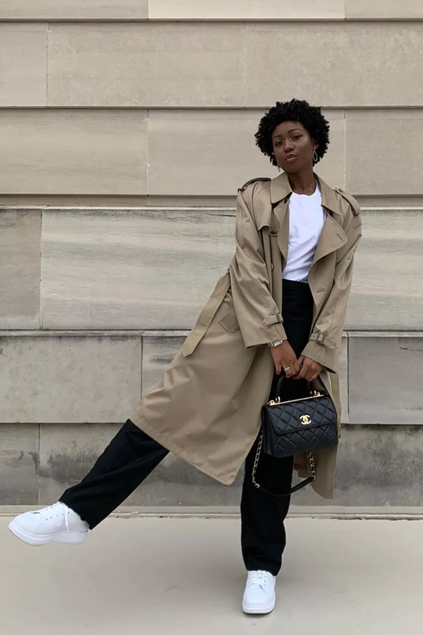 Jean noir large avec trench beige, tee-shirt blanc et baskets blanches