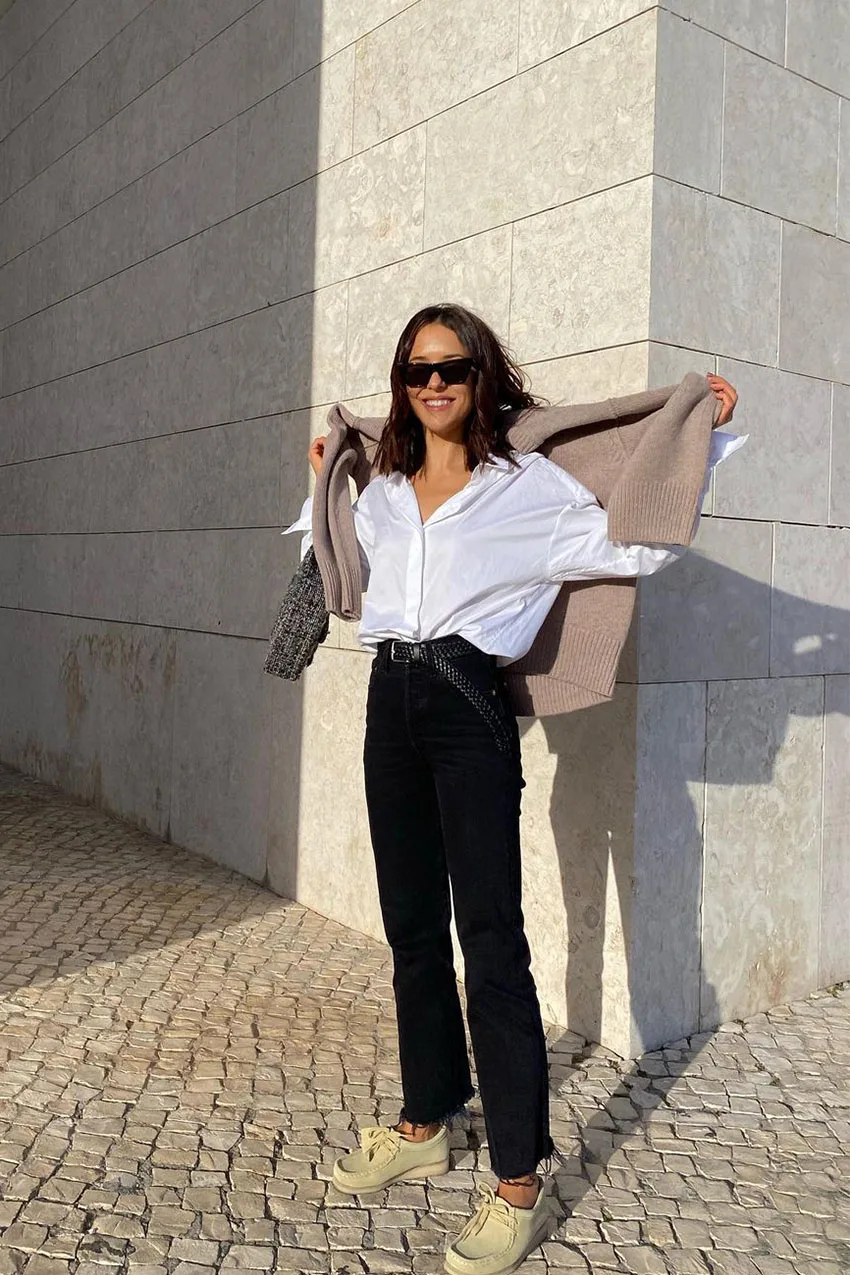 Jean noir raccourci avec chemise blanche oversize et pull noué aux épaules