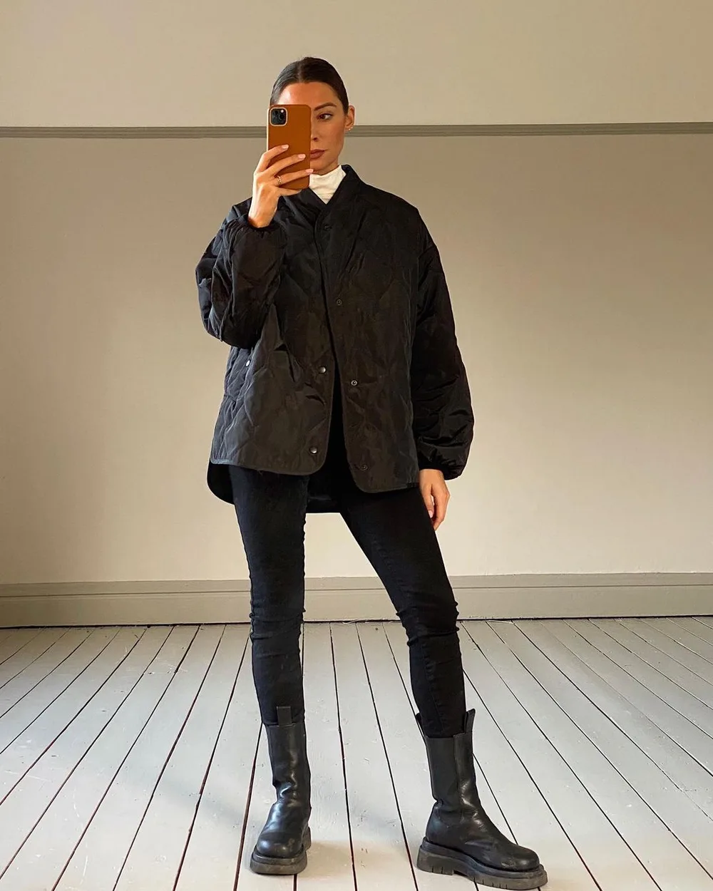 Jean noir skinny avec veste matelassée noire et bottes plates épaisses