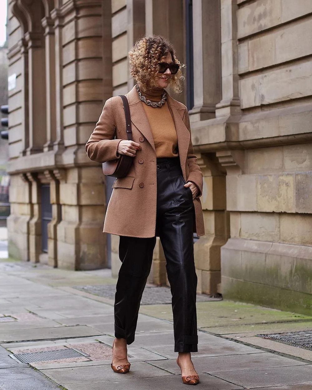 Le blazer camel sur une base noire portée par une femme élégante