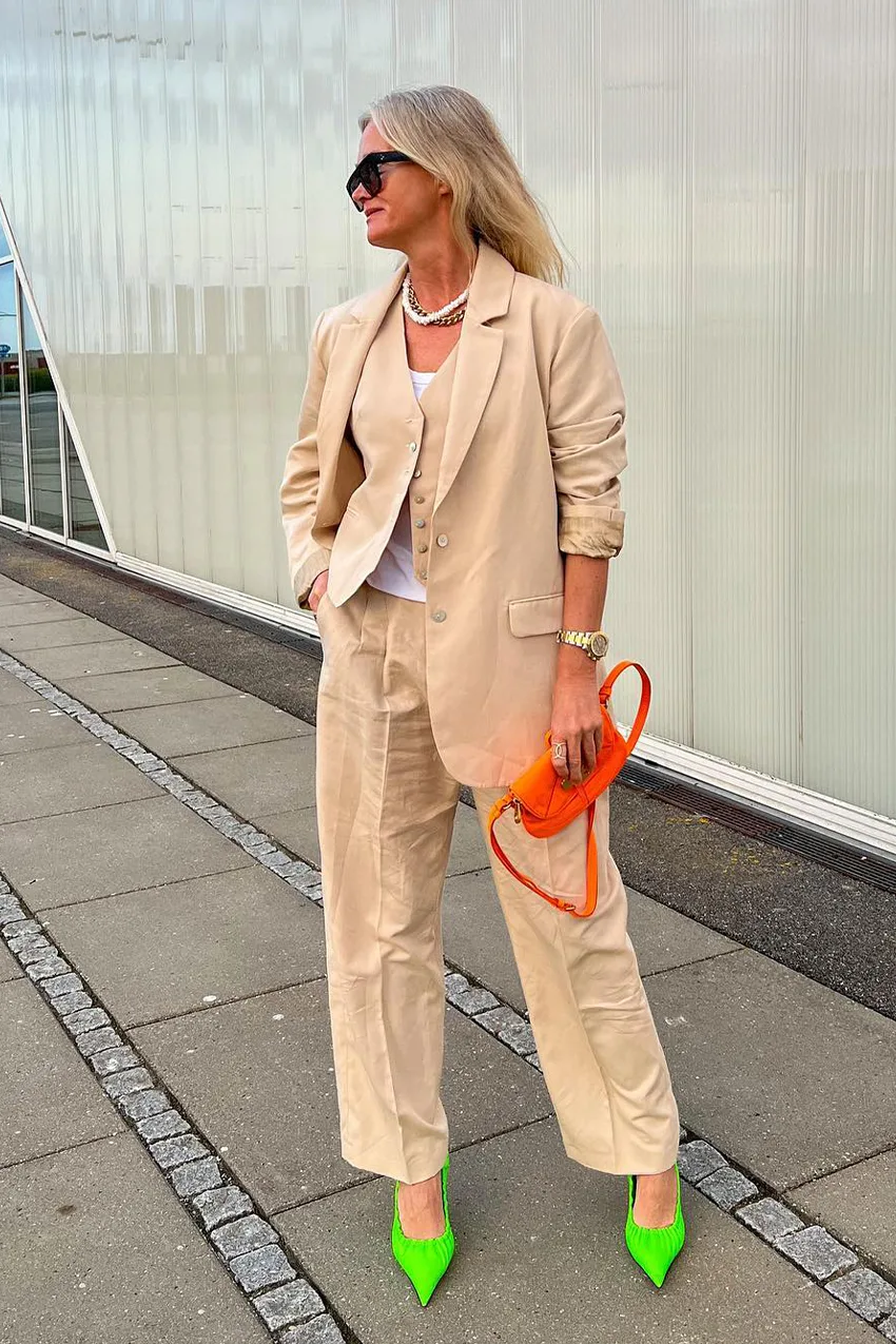 Le costume sable réveillé par des accessoires colorés portée par une femme élégante