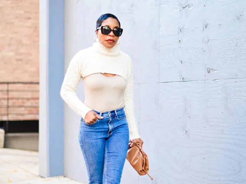 Le pull blanc découpé avec un jean classique portée par une femme élégante