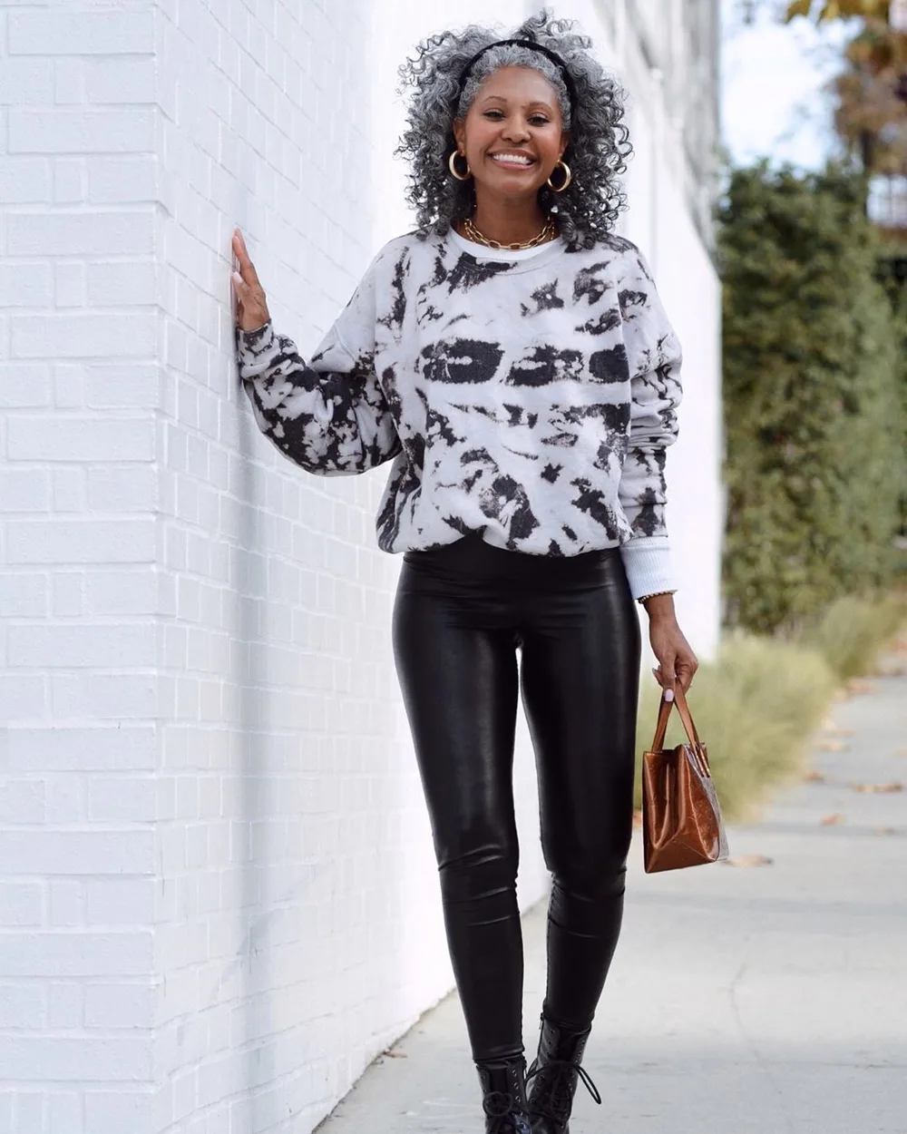 Le pull imprimé avec un pantalon en cuir portée par une femme élégante