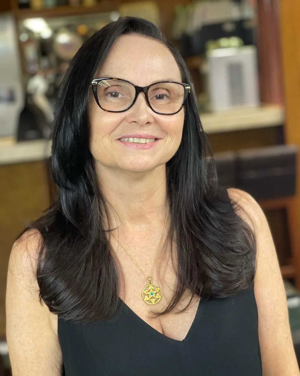 Longs cheveux bruns dégradés sur femme de 60 ans portant des lunettes