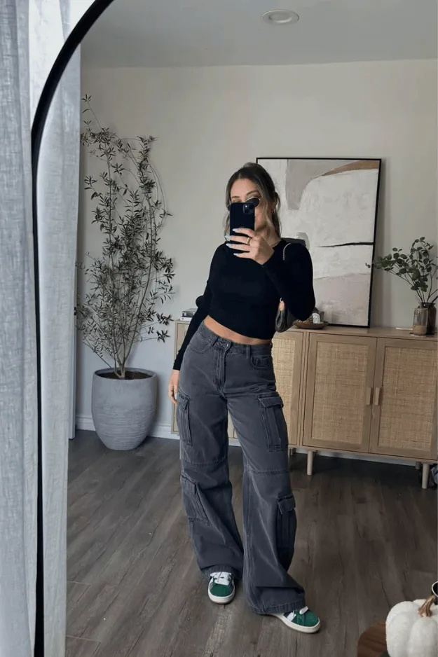 Pantalon cargo gris porté avec un top noir ajusté et des baskets vertes