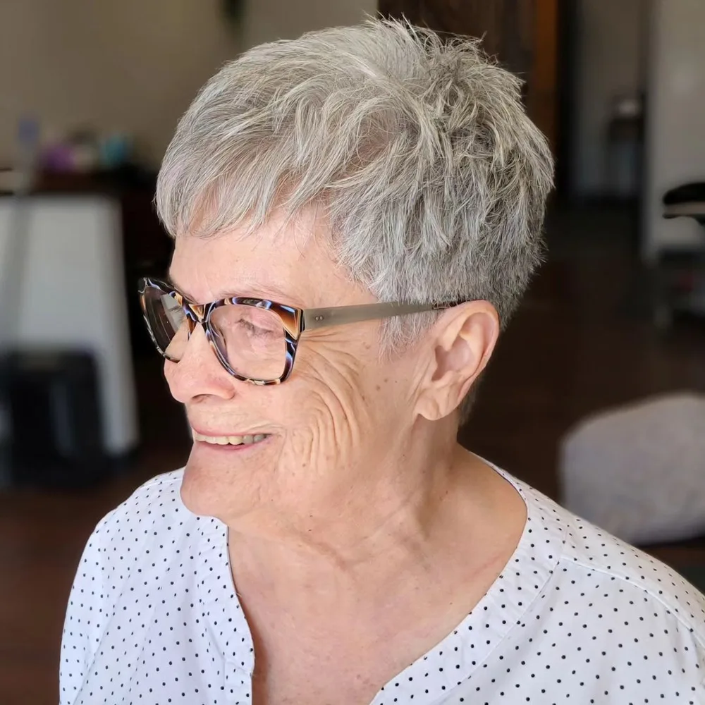 Pixie court choppy texturé gris sur femme de 60 ans avec lunettes