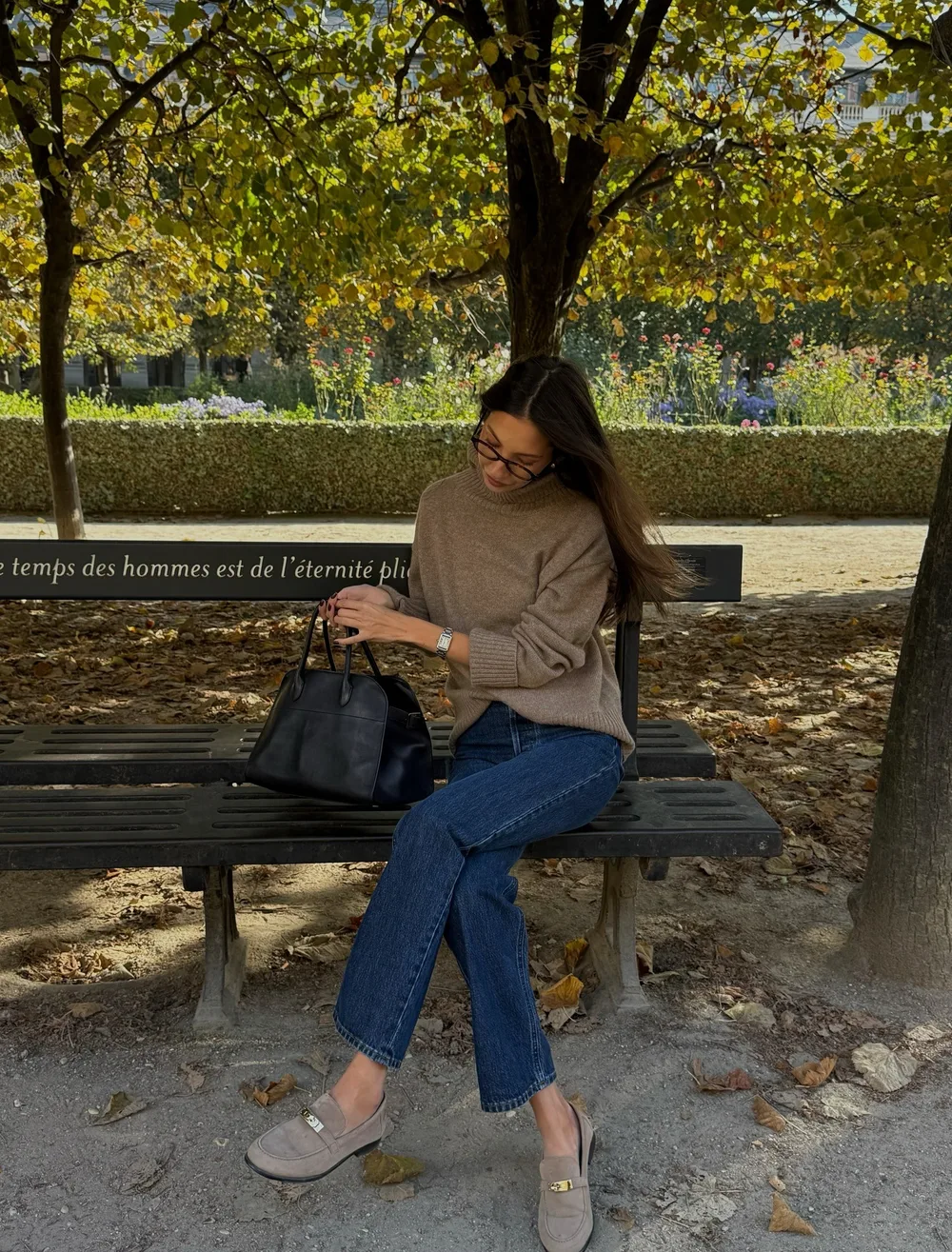 Pull beige et jean brut portés avec des mocassins en daim gris
