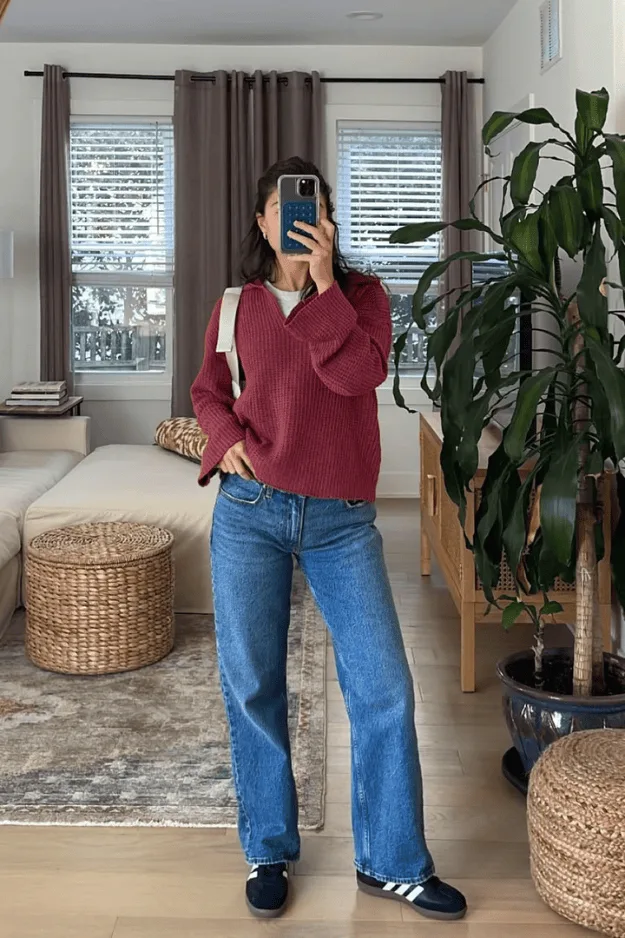 Pull col polo bordeaux oversize avec un jean large et des baskets bleu marine