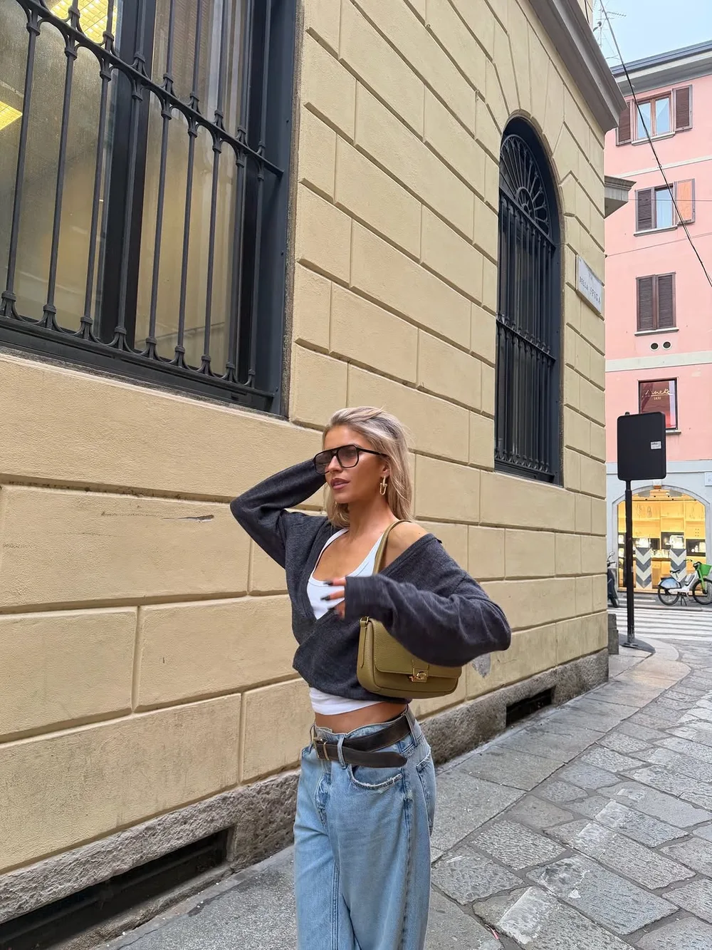 Pull gris court sur débardeur blanc avec jean large et ceinture en cuir