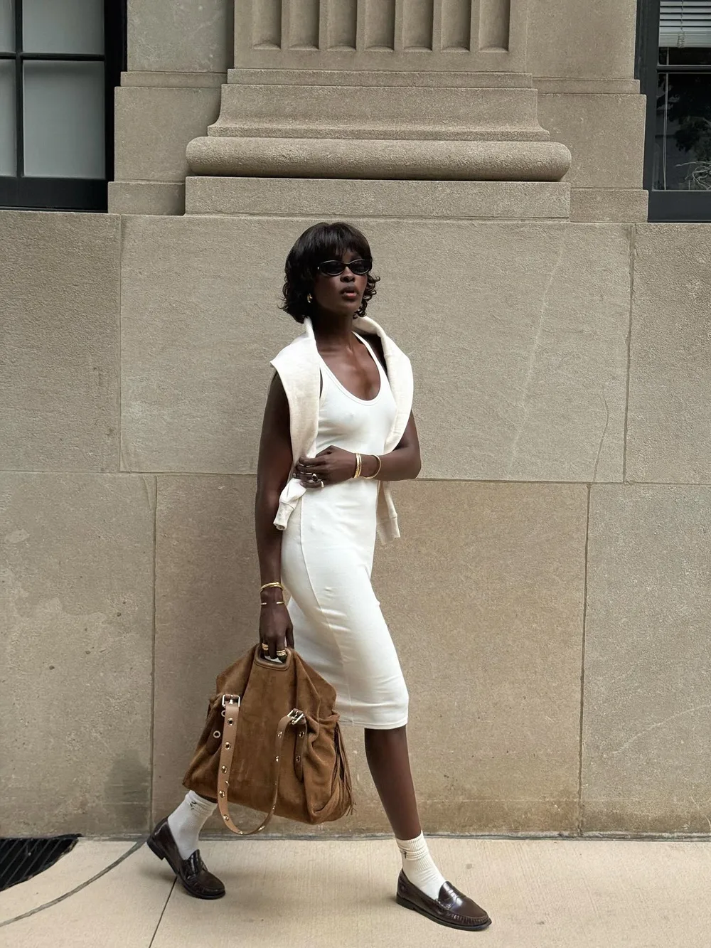 Robe blanche ajustée portée avec un grand sac et des mocassins marron à socquettes