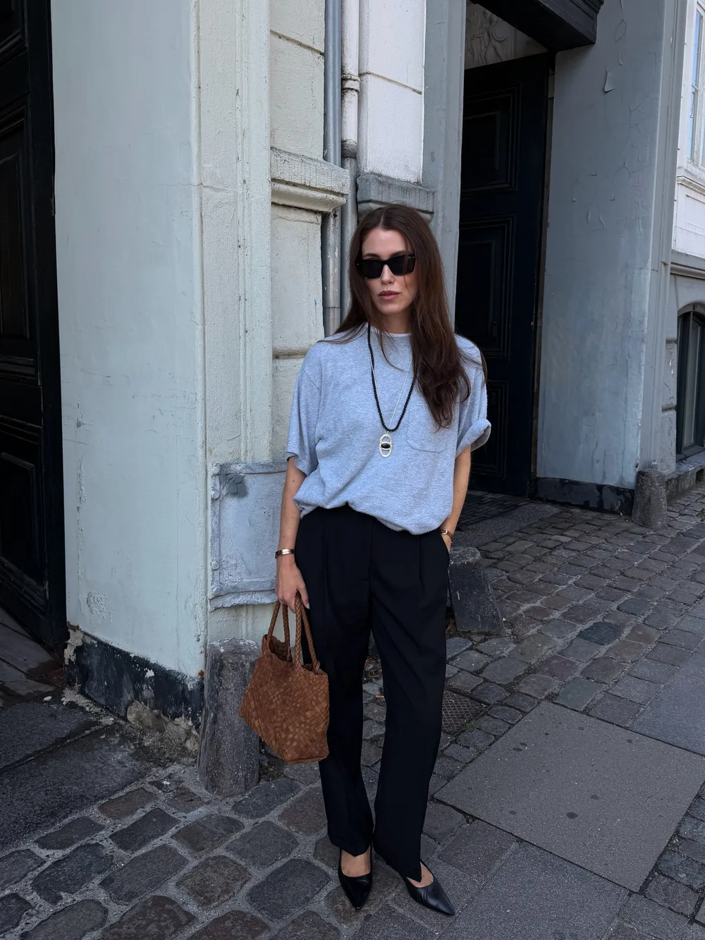 Sac tressé marron porté main avec une tenue noire