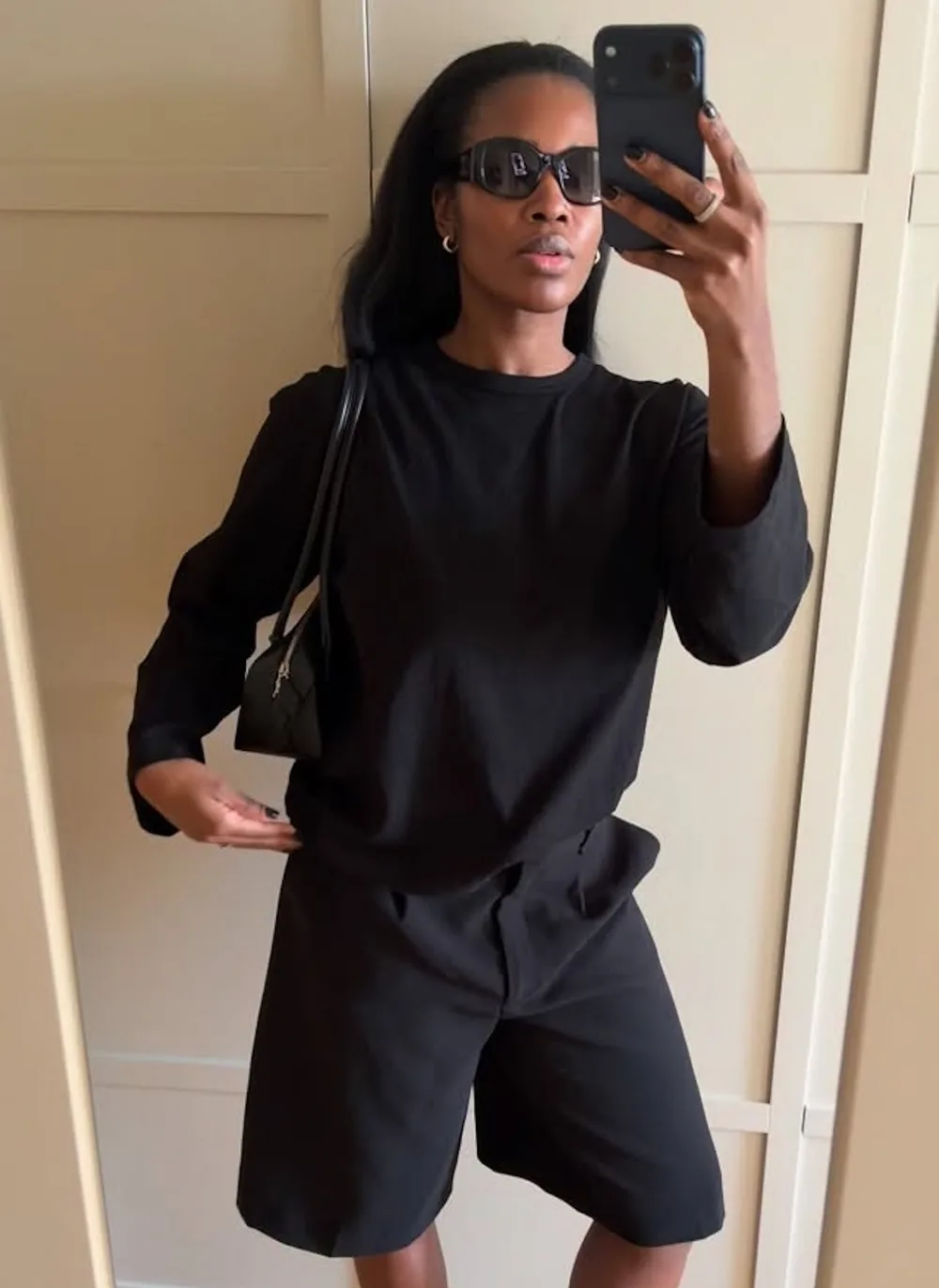 Tee-shirt noir ample à manches longues avec bermuda noir et sac à l’épaule