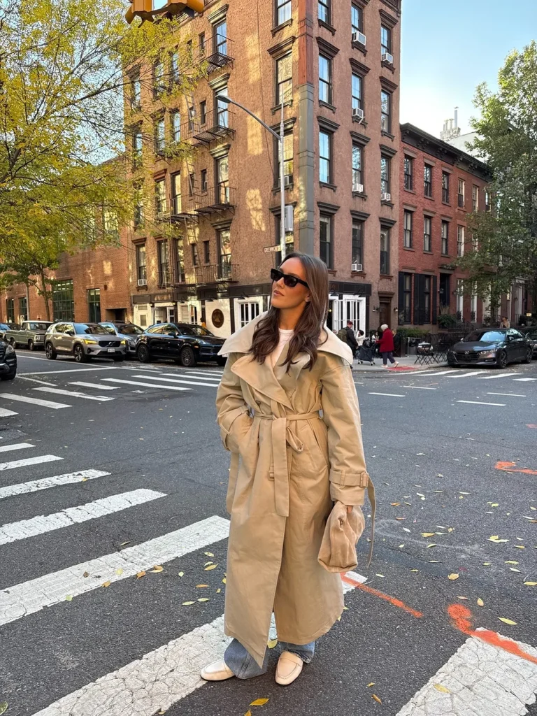 Trench beige porté avec un jean et des mocassins marron dans la rue