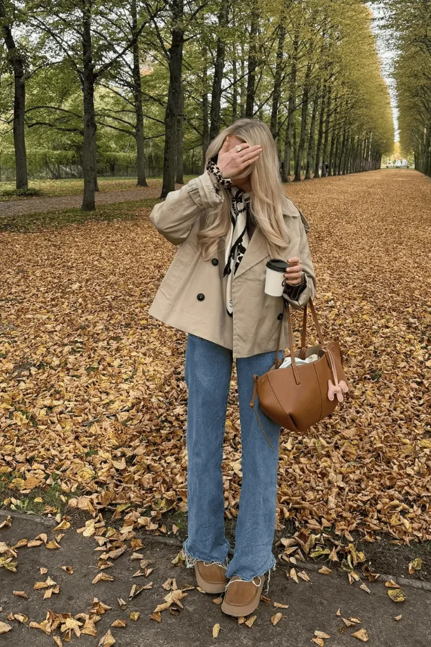 Trench beige porté avec un jean large et des bottes en daim