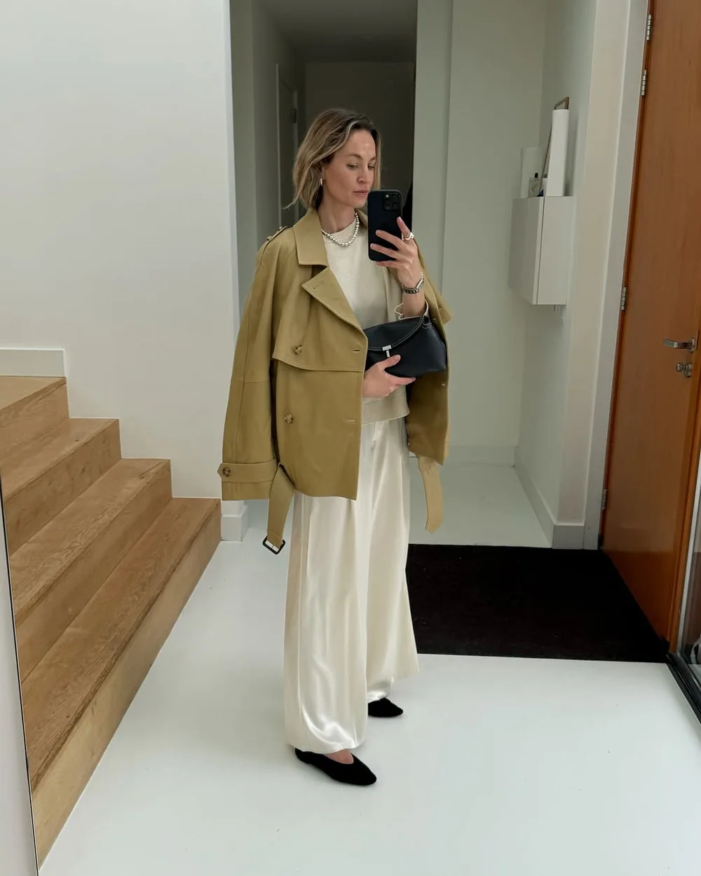 Trench court kaki avec pantalon satiné crème et ballerines noires