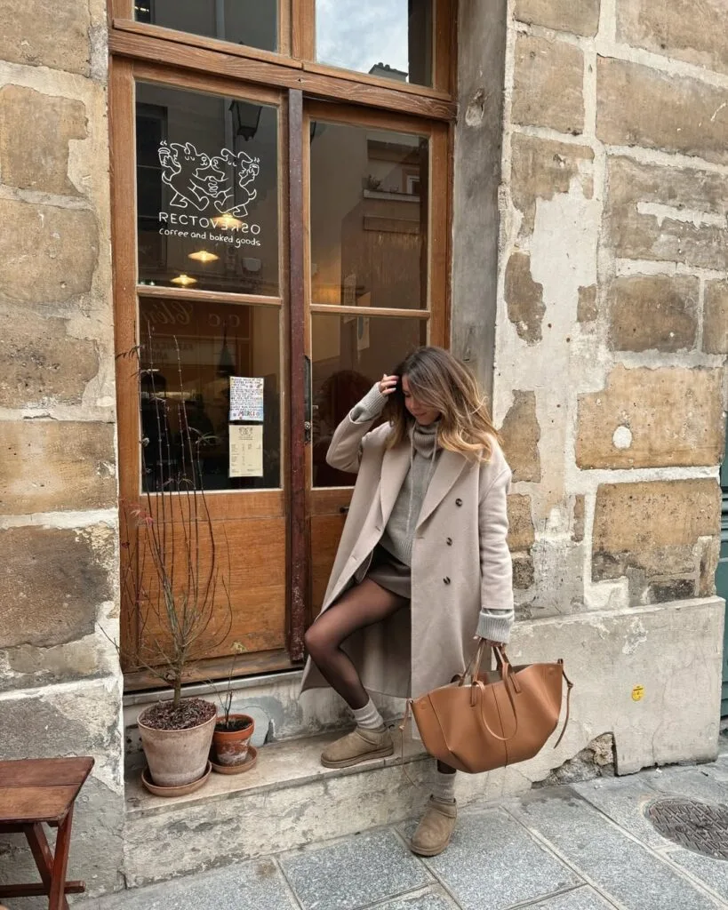 UGG grises avec manteau long beige, mini-jupe et collants bruns