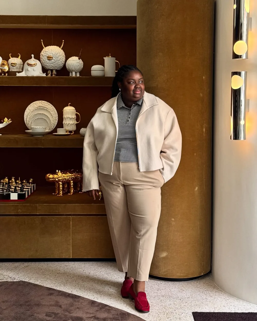 Veste crème et pantalon beige portés avec des mocassins rouges