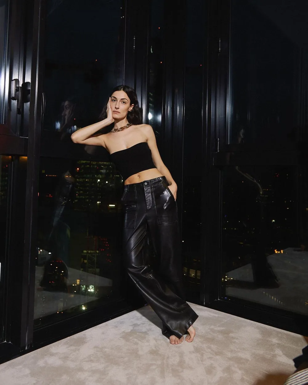 Veste en cuir noire avec bandeau noir et pantalon fluide brillant