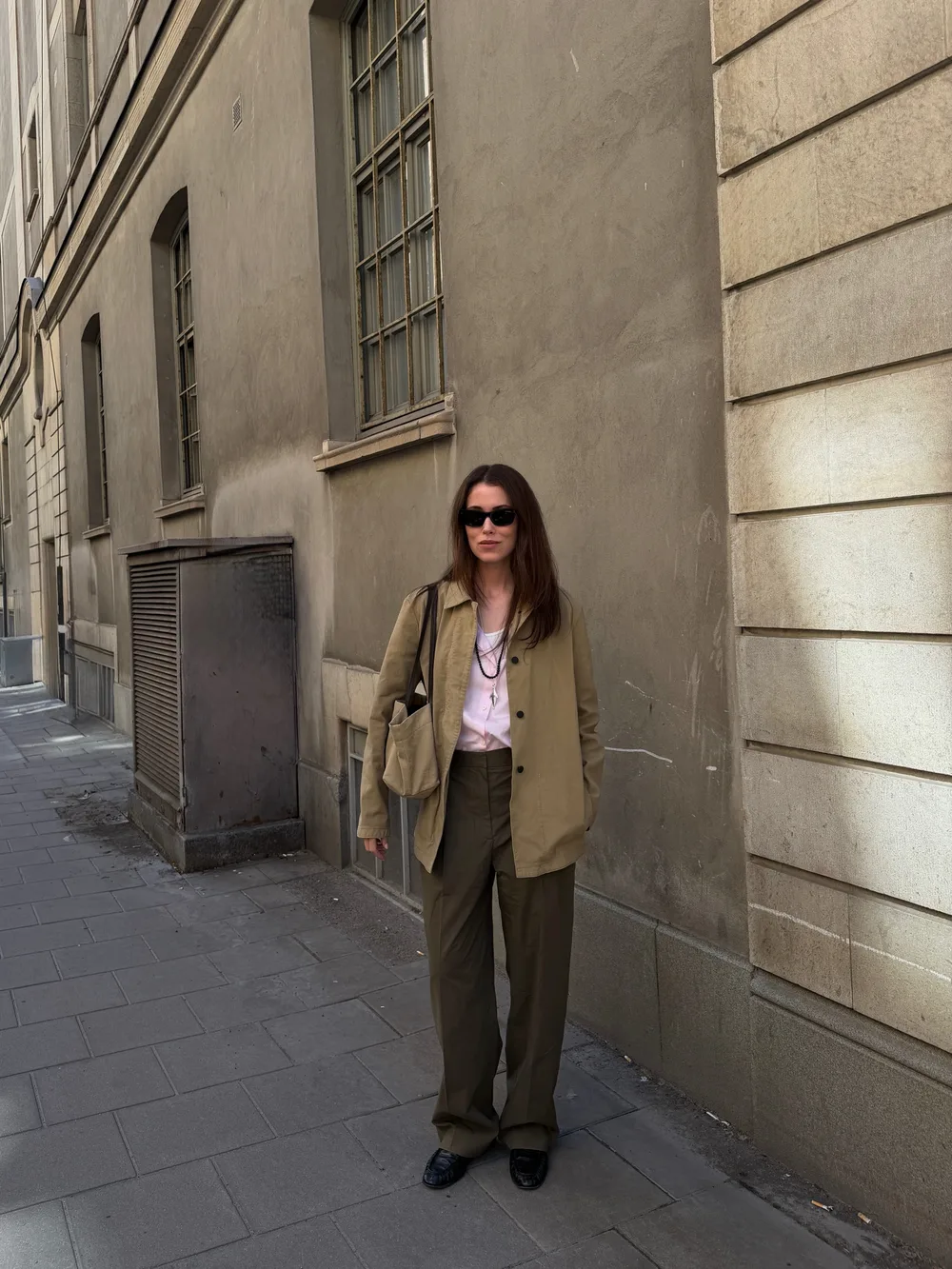 Veste en toile beige avec chemise rose, pantalon brun et mocassins