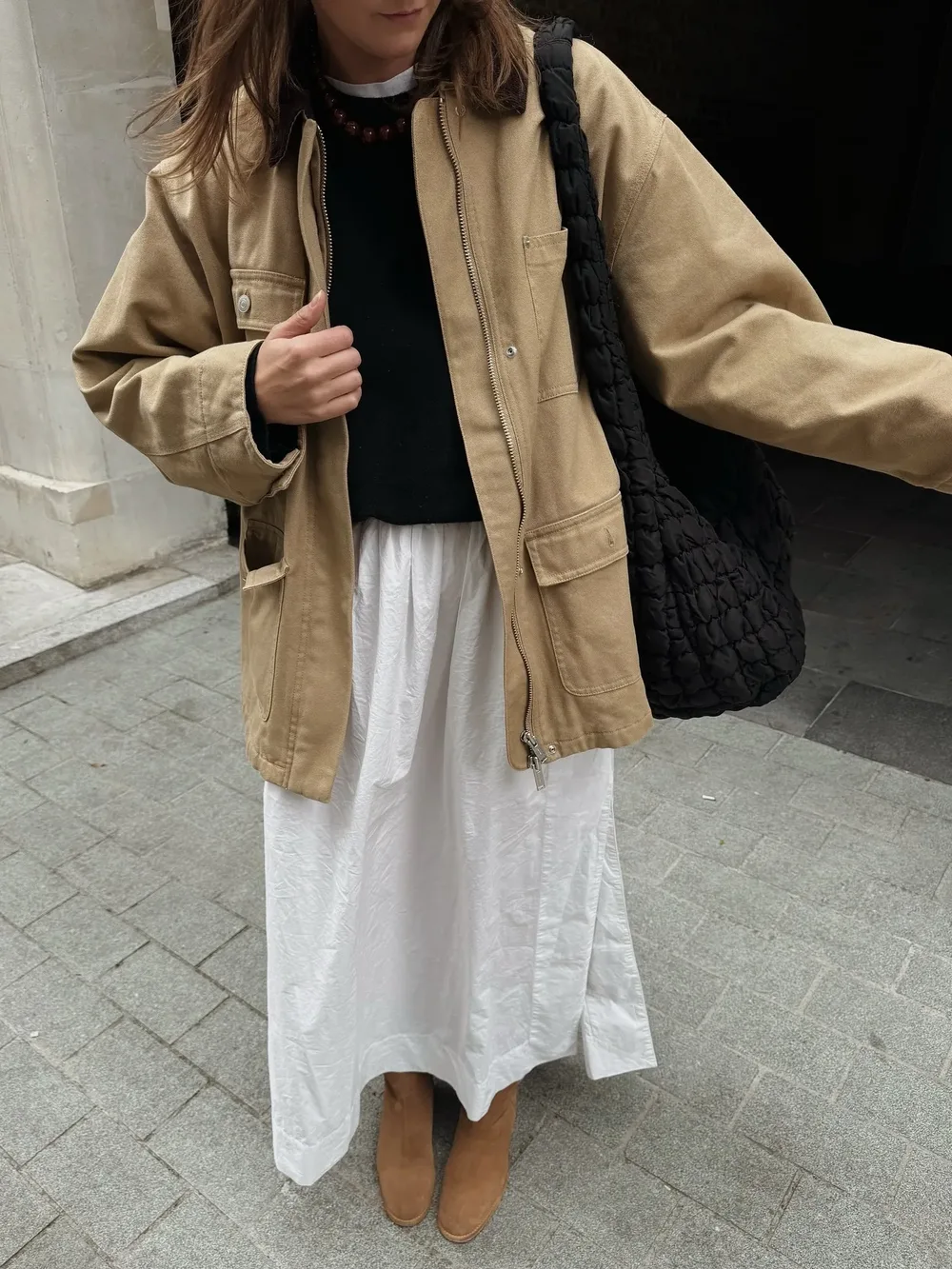 Barn jacket beige portée sur une jupe longue blanche et un pull noir