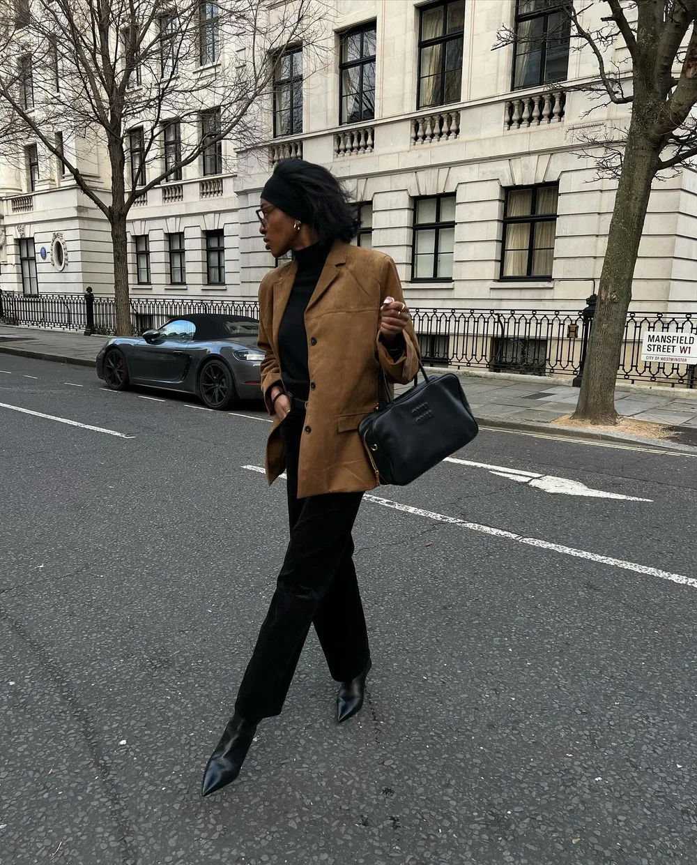 Blazer marron porté avec un col roulé et un pantalon noirs